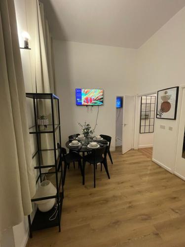 a dining room with a table and a tv on the wall at One Bedroom Flat B in Kentish Town in London