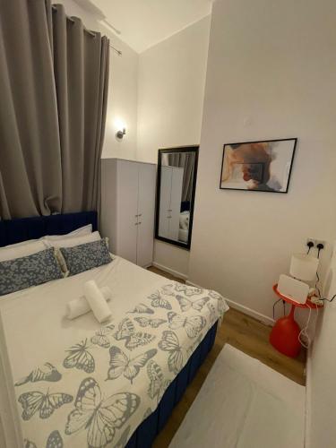 a small bedroom with a bed and a mirror at One Bedroom Flat B in Kentish Town in London