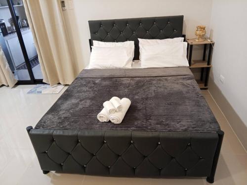 a black bed with two pairs of slippers on it at Affordable Room in Calamba - Rm 2 in Bukal