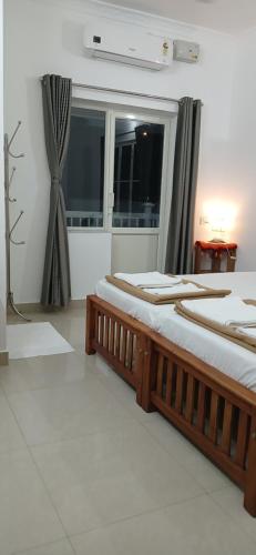 two beds in a room with a window at annies inn homestay in Cochin
