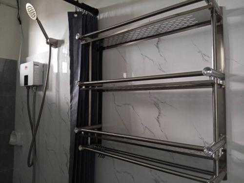 a bathroom with a towel rack and a shower at Affordable Room in Calamba - Rm 2 in Bukal