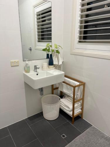 a bathroom with a sink and a mirror at River Retreat Studio in Grays Point