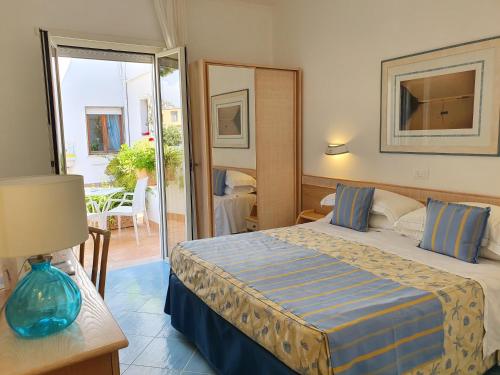 a hotel room with a bed and a balcony at Hotel Aurora in Sperlonga