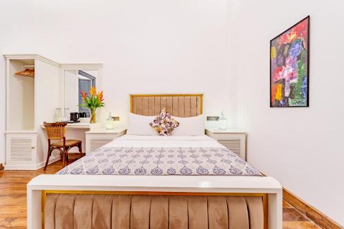 a bedroom with a large bed and a desk at Small House Boutique Guest House in Galle
