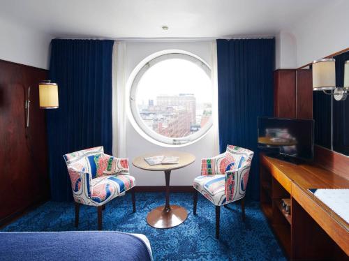 a living room filled with furniture and a window at The Maritime Hotel in New York