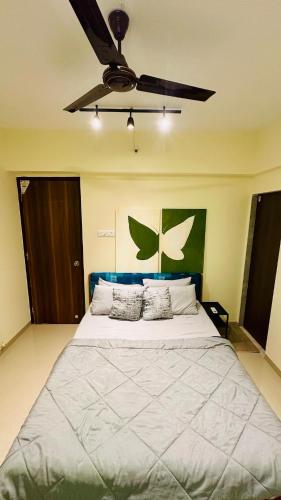 a bedroom with a large bed with a ceiling fan at Sky Escape, Cloud-Level Living in Thane