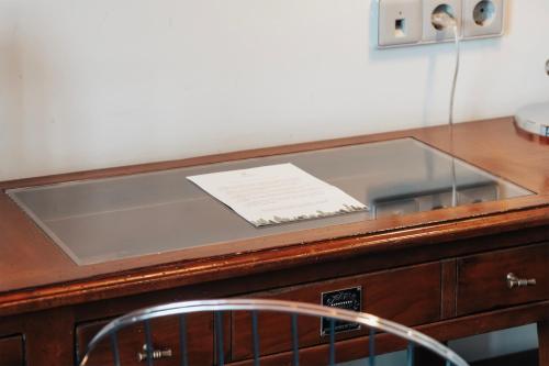 a desk with a glass top with a paper on it at Kabadoni Boutique Hotel in Sighnaghi