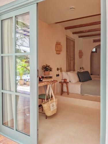 a bedroom with a bed and a door leading into a room at Nomad Hotel & Spa Altea in Altea