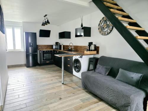 a living room with a couch and a kitchen at Love Room Luxe and Spa - Sauna in Domérat