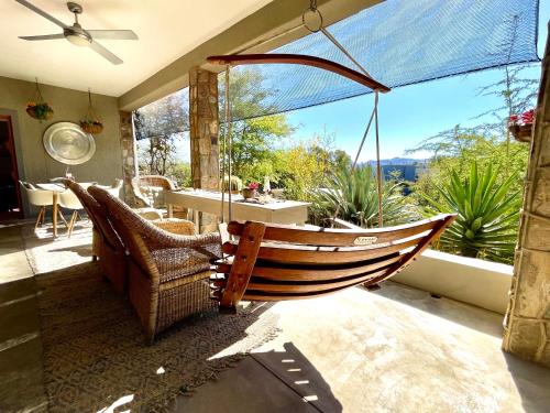 a porch with a hammock and a table and chairs at Bryan's View in Windhoek