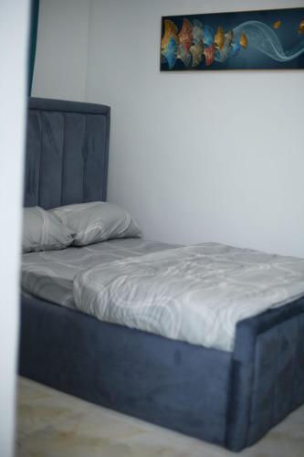 a blue bed in a room with a picture on the wall at LuxSafe Haven Lagos in Lekki