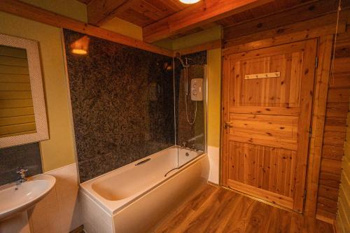 a bathroom with a tub and a sink and a toilet at Lodge 3 in Stirling