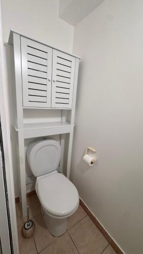La salle de bains est pourvue de toilettes blanches et d'une armoire blanche. dans l'établissement Квартира в отеле, à Beausoleil