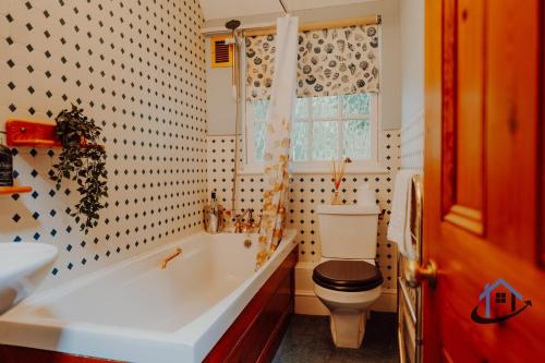 a bathroom with a toilet and a tub and a sink at Unique Boathouse, detached free parking x4 cars in Kingston upon Thames