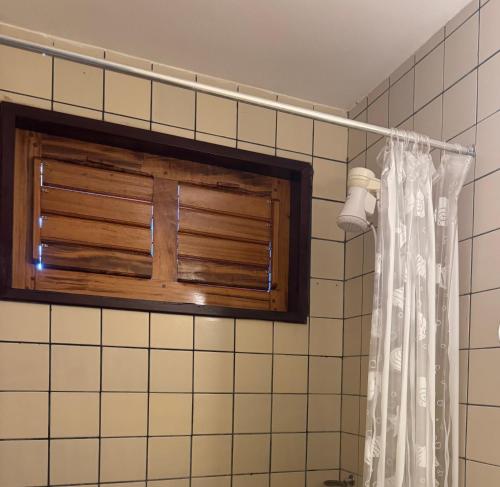 a bathroom with a shower curtain and a window at Villa Jaguaribe in Fortim
