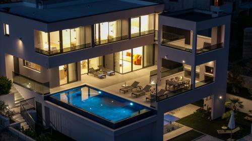 eine Luftaufnahme eines Gebäudes mit einem Swimmingpool in der Unterkunft Villa Pavuza Luxury 4-Bedroom Seaview Villa in Podstrana