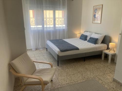 a bedroom with a bed and a chair at Apartamento Socorro in Ronda