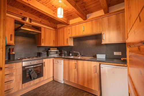 a large kitchen with wooden cabinets and appliances at Lodge 1 in Stirling