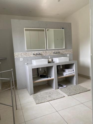 une salle de bain avec un lavabo et deux miroirs dans l'établissement Maison à la campagne avec piscine, à Auriol