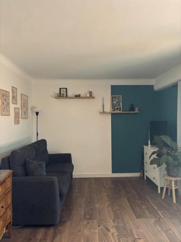 un salon avec un canapé et un mur bleu dans l'établissement Charmant studio avec piscine et jardin, à Cannes