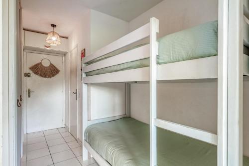 Cette chambre comprend 2 lits superposés et un couloir. dans l'établissement Appartement La Fossette , 4 personnes, 5mn de la plage, WIFI, climatisation, parking, terrasse sans vis-à-vis, au Lavandou