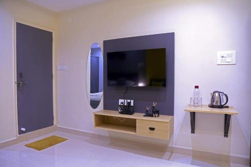 Una sala de estar con un televisor en la pared. en Srinivasam-StudioFlat13-Kondapur, en Lingampalli