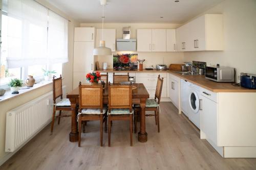 Una cocina con una mesa y sillas en una cocina. en Heideglück, Ferienwohnung, en Schneverdingen