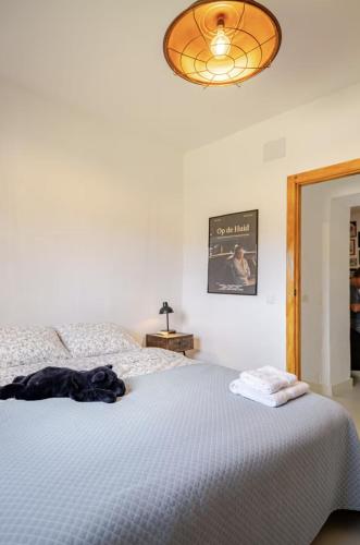 a bedroom with a white bed and a light fixture at Casa Rocas Private Pool with swimjet! in Comares