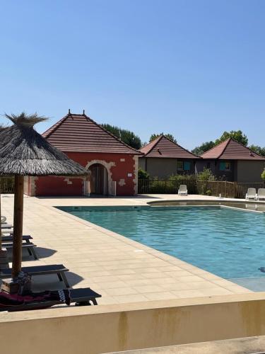 une piscine avec des chaises et un parasol dans l'établissement Appartement 2 chambres, à Prayssac