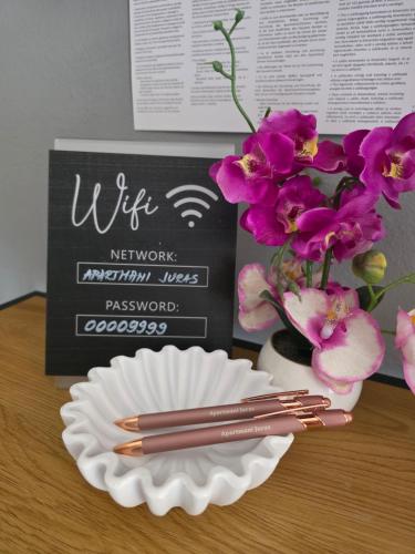 a table with a plate and some chopsticks and flowers at Apartments Ita - Postira in Postira
