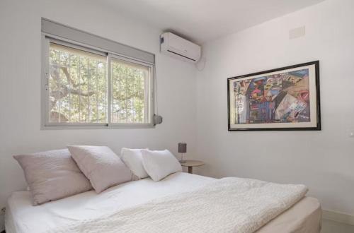 a white bedroom with a bed and a window at Casa Rocas Private Pool with swimjet! in Comares