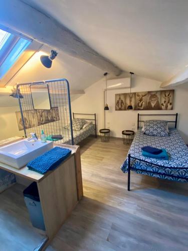 a bathroom with a sink and a bed in a room at Maison de Village in Canet d'Aude