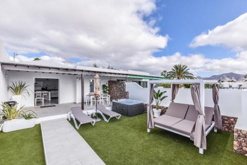 a patio with chairs and a table on a lawn at VILLAS NEW LANZASUITES PLUS in Playa Blanca
