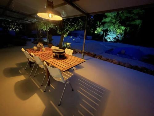 a wooden table and chairs on a patio at night at Casa Rocas Private Pool with swimjet! in Comares