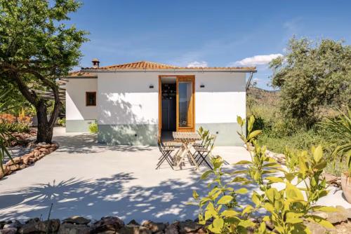 a small white house with a patio and trees at Casa Rocas Private Pool with swimjet! in Comares