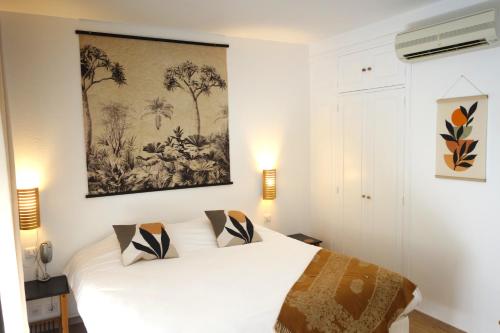 une chambre avec un lit blanc et un tableau au mur dans l'établissement Hôtel La Ségalière Spa Bar, à Cajarc