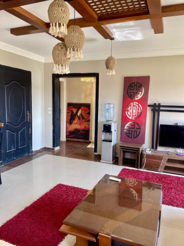 a living room with a table and a red rug at Chalet in Bluebay Asia Resort Ain Sokhna in Ain Sokhna