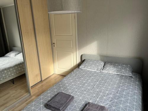 a small bedroom with a bed and a mirror at Ravi 1A Apartment in Pärnu