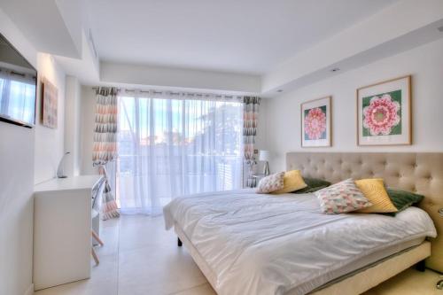 une chambre avec un lit et une grande fenêtre dans l'établissement REF 1147 - Cannes Center - Apartment for rent, à Cannes