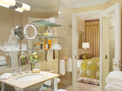 a bathroom with a sink and a mirror and a bed at The Pierre, A Taj Hotel, New York in New York