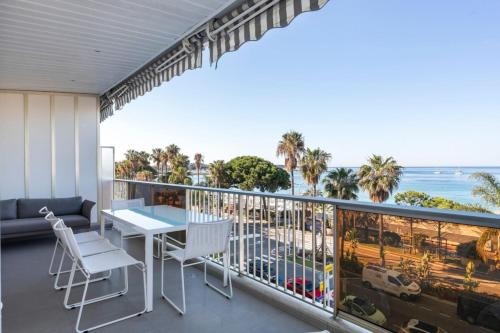 un balcon avec une table et des chaises et l'océan dans l'établissement REF 1426 - Cannes Croisette - Sea view apartment for rent, à Cannes