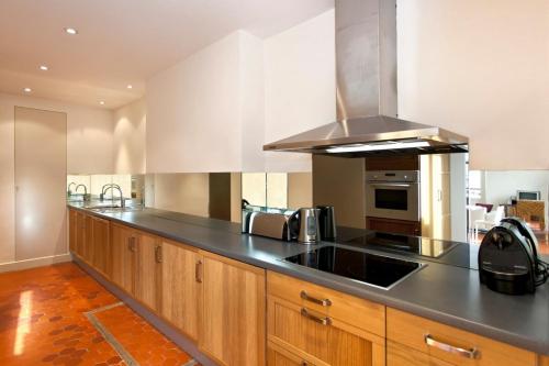 une cuisine avec des armoires en bois et un four à plaques de cuisson dans l'établissement REF 35 - Cannes Center - Duplex apartment for rent, à Cannes