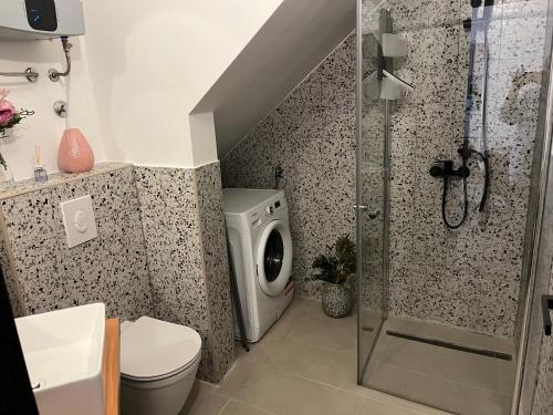 a bathroom with a shower and a washing machine at Apartments Casanova in Vrsar