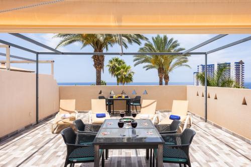 a balcony with a table and chairs and palm trees at Best duplex FREE WIFI in Playa Paraiso