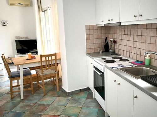 een keuken met een tafel en een fornuis bovenste oven bij Mountain View Apartment Lefkada in Apolpaina