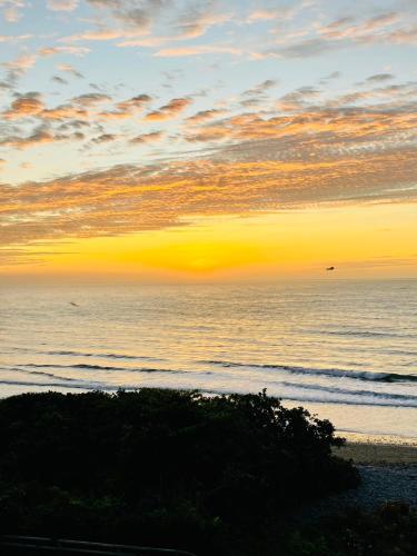 a sunset over the ocean with a beach at Taitung Blue Sea Villa in Chenggong
