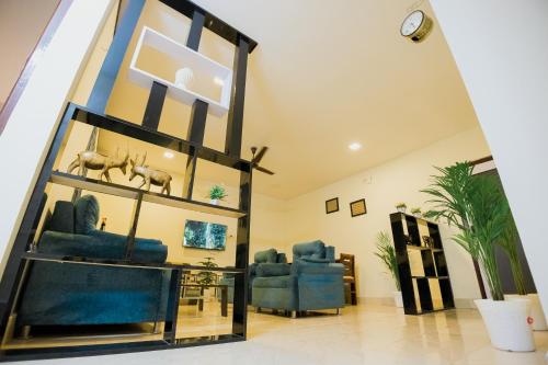 a living room with blue chairs and a mirror at Phagun Suites Homestay in Dibrugarh