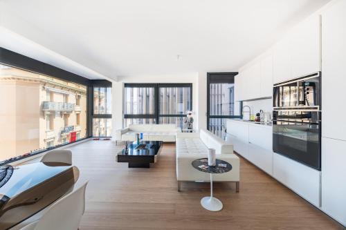 une cuisine avec des armoires blanches et un salon dans l'établissement Luxury 3BR Apartment with Sea View, à Beausoleil