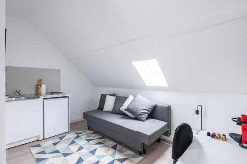 un salon avec un canapé et une cuisine dans l'établissement Studio moderne proche centre ville & Gare, à Amiens