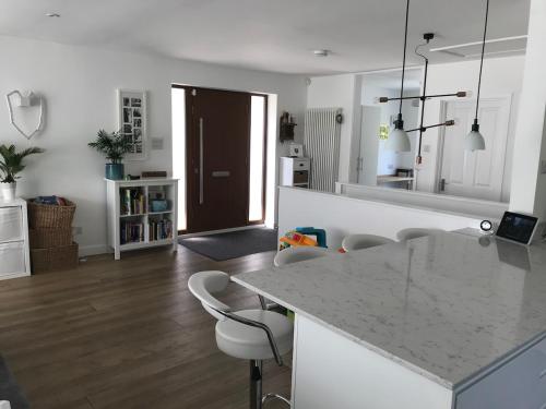a kitchen and living room with a counter and chairs at Featured on Channel 4 with George Clarke with lazy spa in Bournemouth